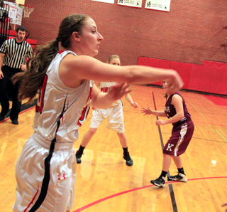 Hailey Danly guns a pass towards a teammate under the basket. Also shown is Leah Higgins.
