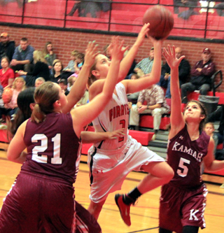 Kylie Tidwell drives between Kamiah defenders for a lay-up.