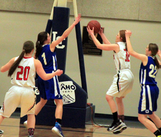 Josie Peery grabs a defensive rebound. Also shown is Hailey Danly.