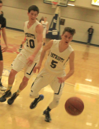 Dean stubbers chases after a loose ball in the Kendrick game. Also shown is Tyler Krogh.