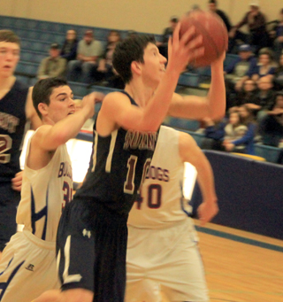 Tyler Krogh goes for a layup against Rockland. He scored 66 points in the 3 games at State. At left is Patrick Chmelik.