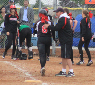 Hailey Danly gets congratulated by coach Jeff Martin as she rounds third after hitting a go-ahead grand slam homer against Potlatch.