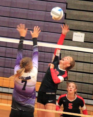 Nicole Poxleitner spikes the ball against Kellogg at the Lewiston Tournament as Mykaela McWilliams gets ready for a possible return.