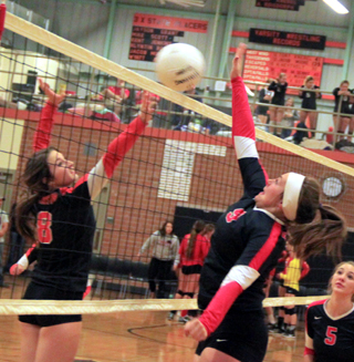 Sydney Bruner jousts at the net with a Pomeroy player. At right is Mykaela McWilliams.