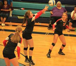 Angela Wemhoff makes a pass on a Lapwai serve as Leah Higgins, left, and Chaye Uptmor, right, watch.