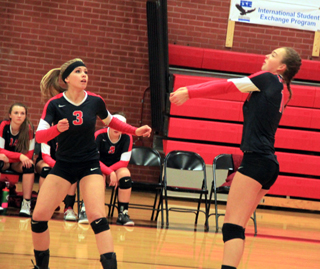 Nicole Poxleitner makes a pass as Chaye Uptmor watches on Senior Night against Grangeville