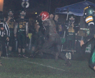 Luke Wemhoff, his uniform caked with mud, takes off around right end for one of his 5 touchdowns.