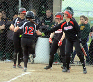 Sarah Ross is greeted at the plates by happy teammates after her 3-run homer against Potlatch.