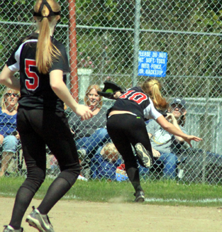 Shortstop Kylie Tidwell makes a backhanded catch of a short fly ball near the foul line against Troy as Leah Higgins watches.