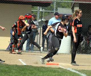 Sam Remacle rounds first with an RBI single as Faith Uhlenkott scores in one of the Troy games.