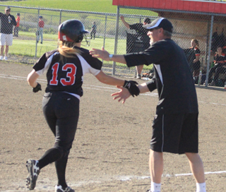 Coach Jeff Martin congratulates Sam Remacle as she rounds third after her first ever over-the-fence homer Monday against Kendrick.