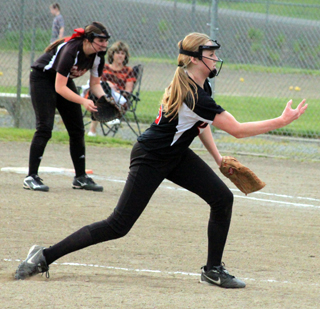 Leah Higgins pitches in the play-in game against Kamiah. Also shown is first baseman Sydney Bruner.