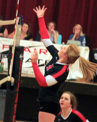 Josie Peery looks to tip the ball at the net against Potlatch. Angela Wemhoff watches.