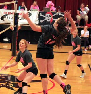Angela Wemhoff goes high for a spike on Dig Pink night against Lapwai. Also shown are Josie Peery and Theresa Wemhoff.