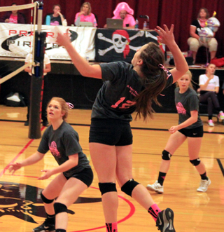 Angela Wemhoff goes high for a spike on Dig Pink night against Lapwai. Also shown are Josie Peery and Theresa Wemhoff.