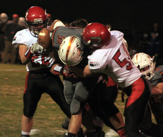 Jace Perrin makes a tackle while Owen Anderson tries to take the ball away from a Troy runner.