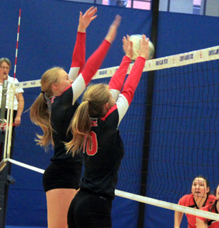 Cousins Leah and Jordyn Higgins go for a block in the Troy match.