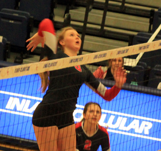Leah Higgins goes for a kill against Genesee as Mattie Pecarovich watches.