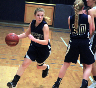 Lexi Currier drives past a pick set by Jessie Sonnen in Summit’s game at Logos.