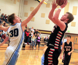 Spencer Schumacher shoots against Ambrose as Devin Ross looks on.
