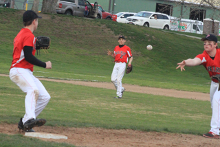 First baseman Dereck Arnzen tosses to pitcher Owen Anderson, covering first for an out against Lapwai. Also shown is third baseman Dalton Ross.