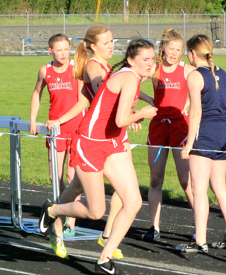 Jordyn Higgins hands off to Ciara Chaffee in the 4x400 as teammates Laney Uhlenkott and Theresa Wemhoff cheer them on.
