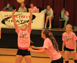 Ashton Landers sets the ball against C.V. as Ellea Poxleitner appears ready to go for the spike and Theresa Wemhoff watches.