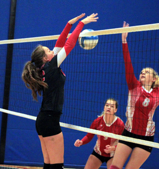 Ellea Poxleitner blocks the ball against C.V. at District.