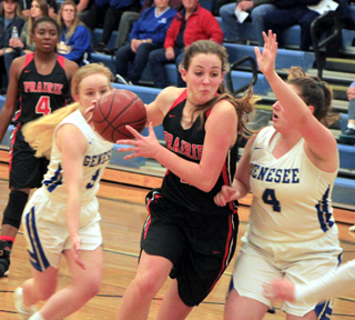 A determined looking Alexis Hiler takes the ball to the hoop at Genesee. Madison Shears looks on.