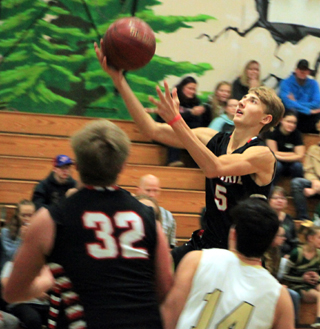 Taylor Ott goes for a layup at St. Maries. Spencer Schumacher gets ready for a possible rebound.