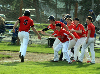 Tate Berdoy is greeted at home plate after his home run at Genesee.