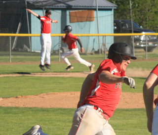Coach Kyle Westhoff waves Chase Kaschmitter home as Dean Johnson rounds first on a bases clearing 3-run double in the top of the 7th against C.V. at District.