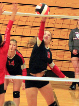 Delanie Lockett at the net against Clarkston as Halle Klapprich watches.
