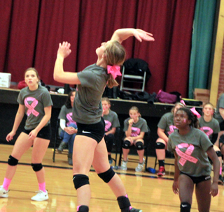 Ellea Uhlenkott goes up for a spike. Also shown on the court are Delanie Lockett and Madison Shears.