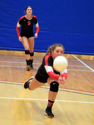 Ashton Landers dives after the ball to make a set in the C.V. match. In the background is Ellea Uhlenkott.