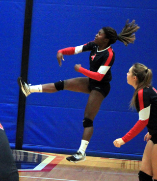 Hair and legs are splayed as Madison Shears spikes the ball against Lapwai at District as Ashton Landers watches after making a set.