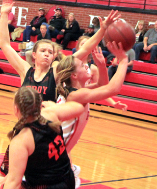 Ellea Uhlenkott pushes between two Troy defenders for a shot.