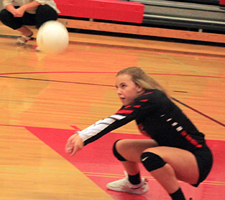 Delanie Lockett gets low for a service dig against Troy.