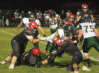 Dean Johnson grabs the runners shirt while T.J. Hibbard grabs a lef and another Prairie defender helps stop this play for a loss.