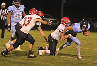 Dean Johnson tackles Lapwai’s quarterback for a loss as Jesse Cronan moves in to help.