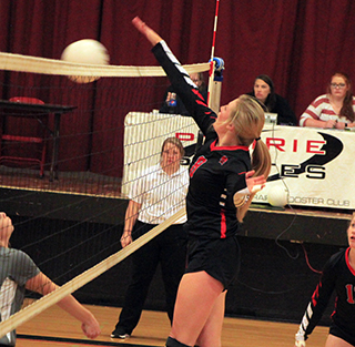 Laney Forsmann knocks down a ball at the net against Highland.