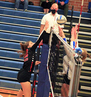 Jade Prigge jousts at the net with a Genesee player in the second Genesee match.