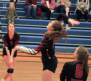 Jade Prigge goes for a spike against Kamiah as Tara Schlader and Delanie Lockett watch.