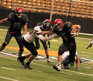 T.J. Hibbard stiffarms an Oakley defender as he breaks loose for a 47-yard touchdown that put Prairie up 40-36 in the 4th quarter. At left is Matt Coppernoll.