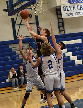 Cole Schlader manages to get a shot up despite being triple teamed at Orofino. Photo by Shelley Schlader.