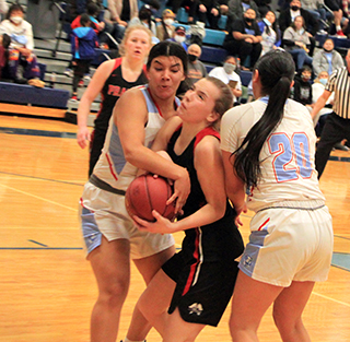 Delanie Lockett gets sandwiched by a pair of Lapwai players in the District Championship game. Also shown is Kristin Wemhoff.