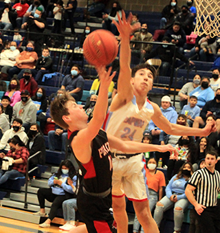 Lane Schumacher has his shot contested in the District Championship game at Lapwai last Friday.