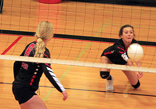 Ali Rehder digs up a serve against Kamiah as Laney Forsmann watches.