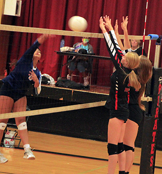 Alli Geis and Tara Schlader go up to block a Lapwai hitter. Geis managed to get a hand on the ball to score for Prairie.