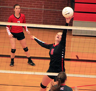 Laney Forsmann reaches to tip the ball against C.V. Also shown is Olivia Klapprich.